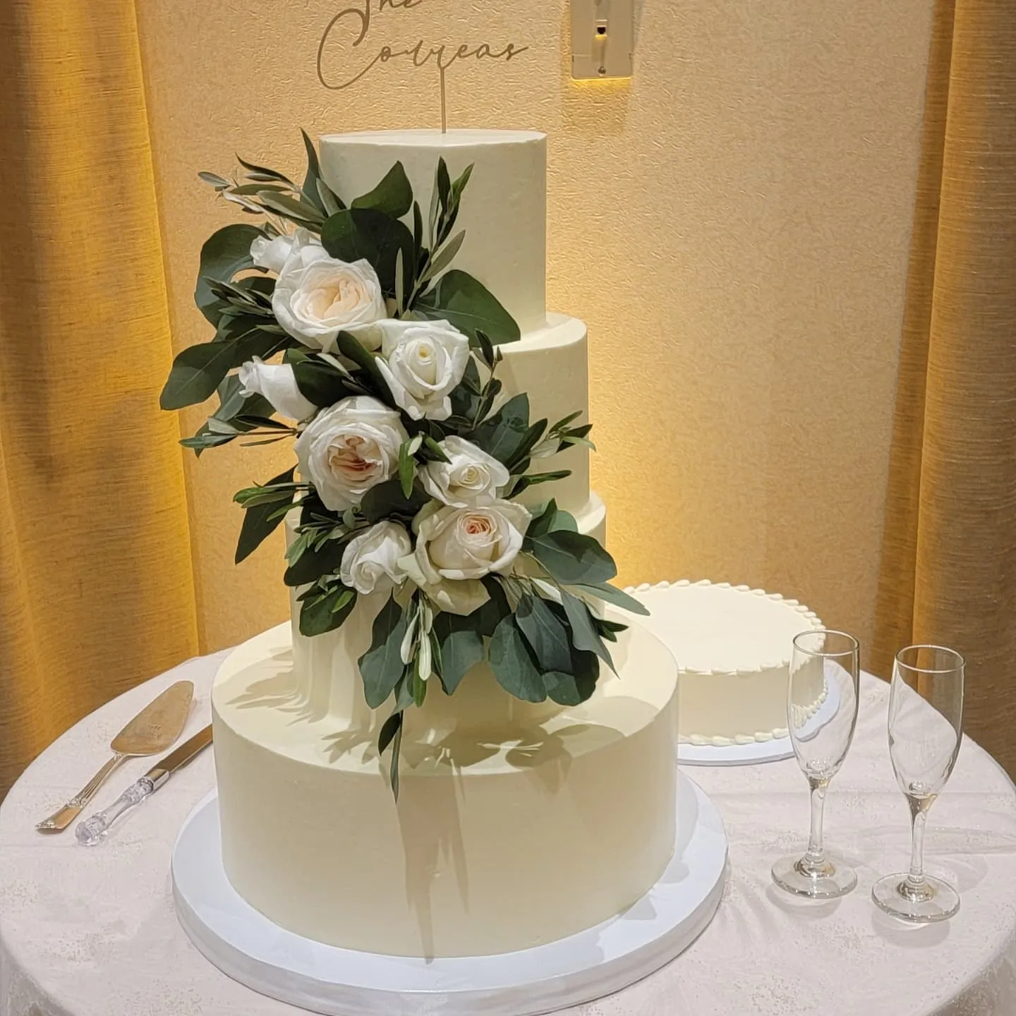 Three-tier white wedding cake with fresh roses