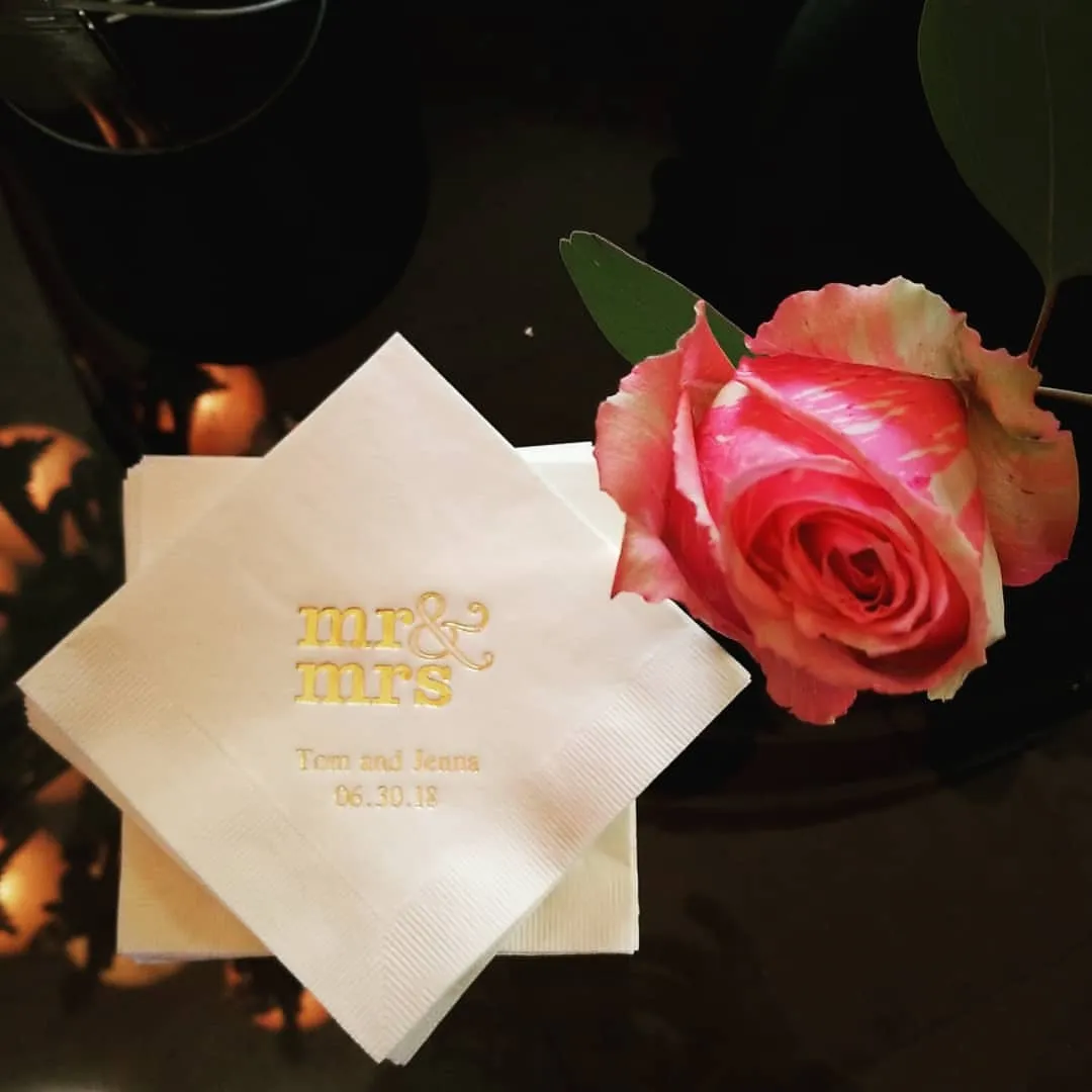 Mr and Mrs cocktail napkin beside a pink rose