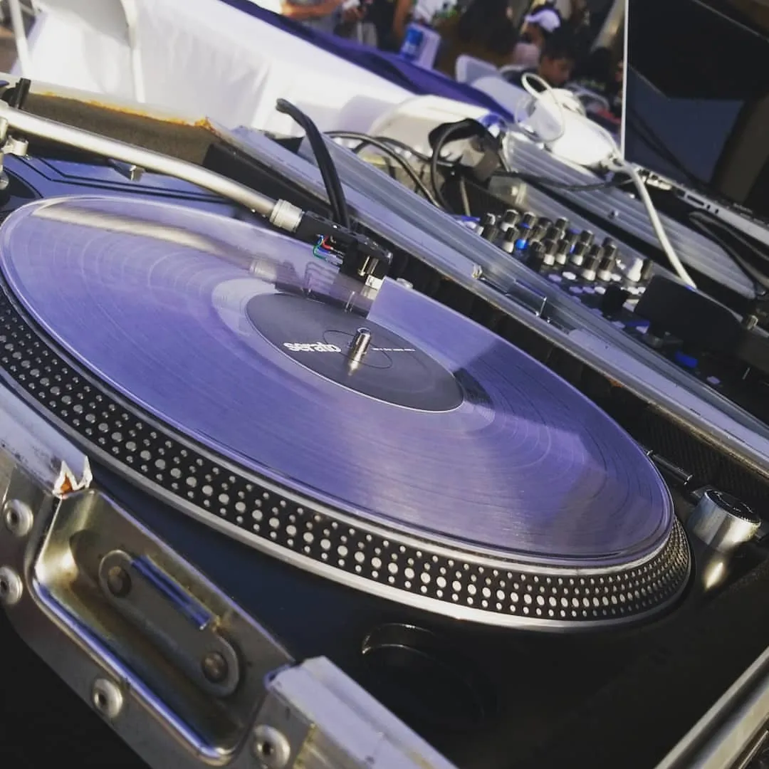Close view of a tonearm and cartridge on a spinning record